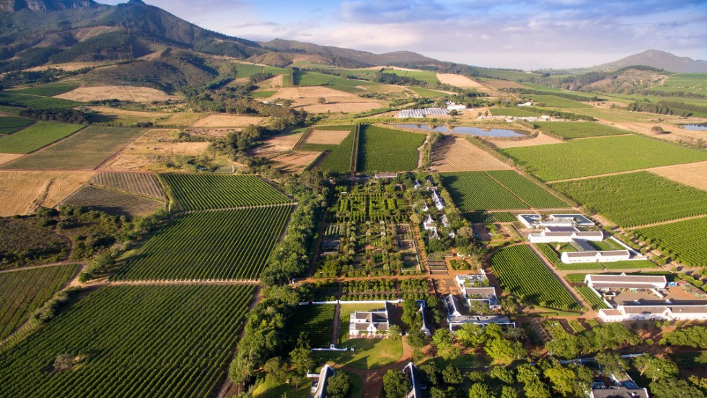 An aerial view of Babylonstoren: the garden grid, vineyards, Cape Dutch farm buildings and the mountains beyond